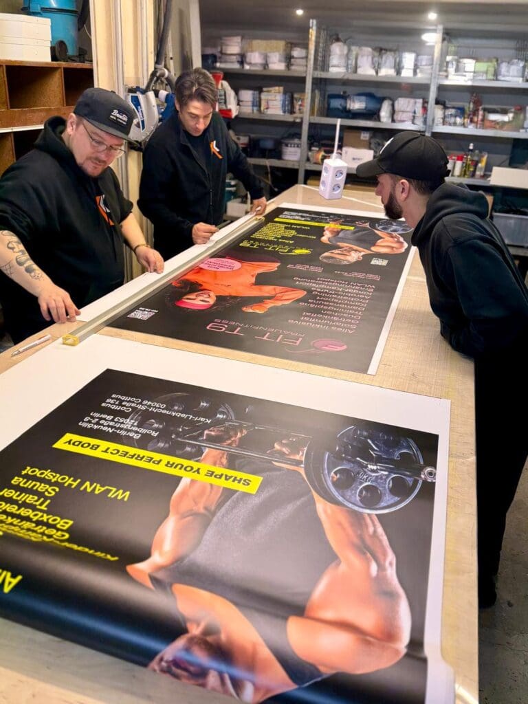 Über uns 2 Team in Berlin während der Produktion eines Roll-Ups – Präzision und Qualität in jeder Phase.